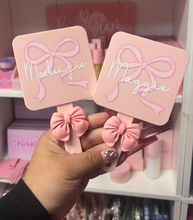 Load image into Gallery viewer, 👉 Custom name bow mirror and comb set being held in hand with pink aesthetic background
